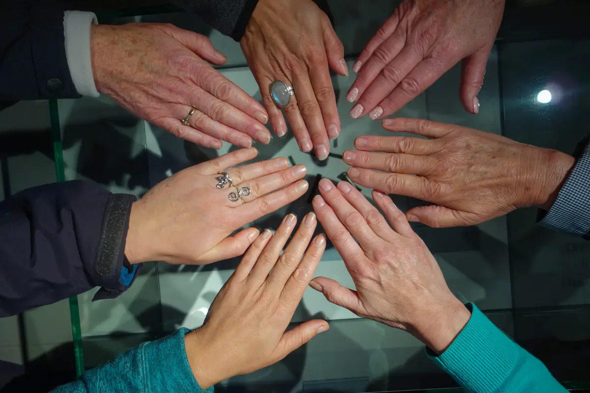 Handen van vrouwen die samen een cirkel vormen